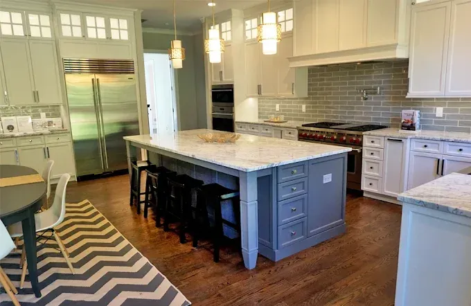 Spacious kitchen with a large island, stainless steel appliances, and wood flooring.