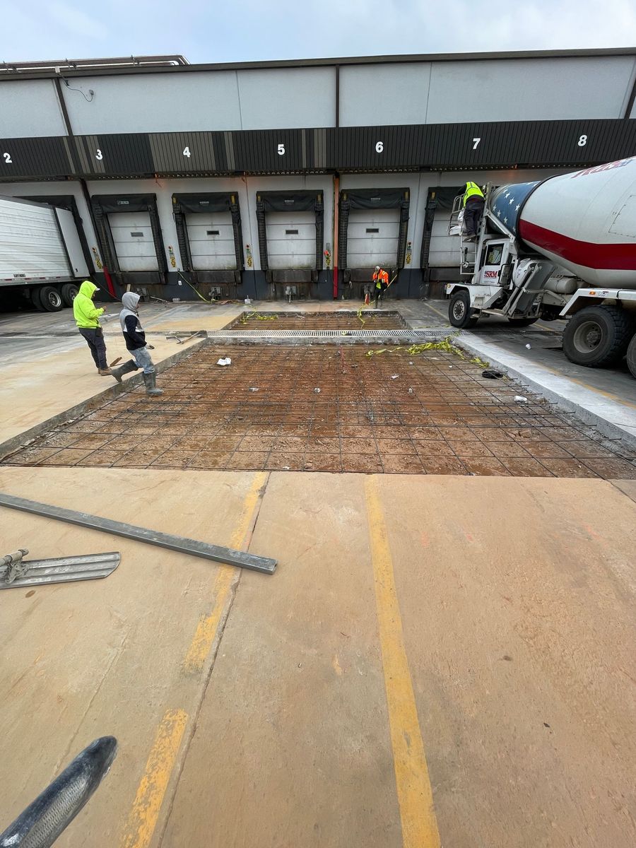 A man is cutting concrete on a highway with a machine.