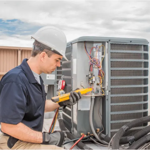Doctor Air HVAC Corp. -  A man wearing a hard hat is working on an air conditioner.