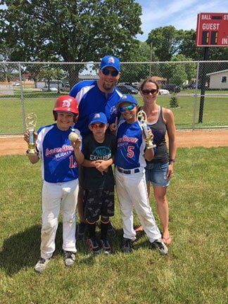Jeremiah, Jessica, and their sons together on a baseball field - experienced master plumber in Inver Grove Heights, MN
