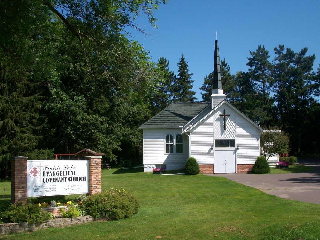 A man is giving a speech in front of a Christmas tree