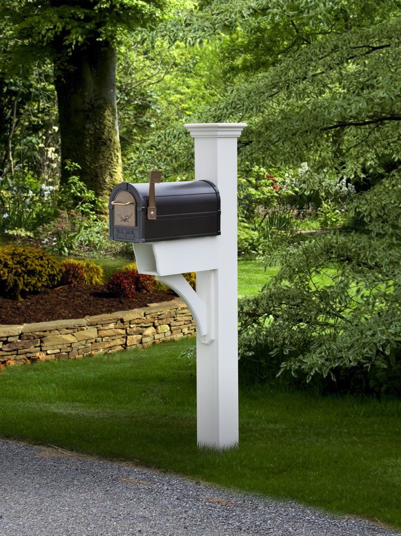 A white post with a black mailbox attached to it