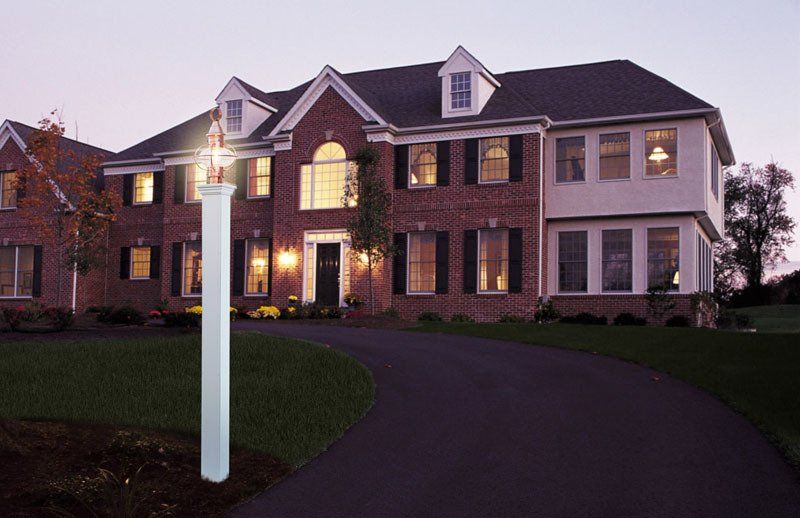A large brick house with a white pole in front of it