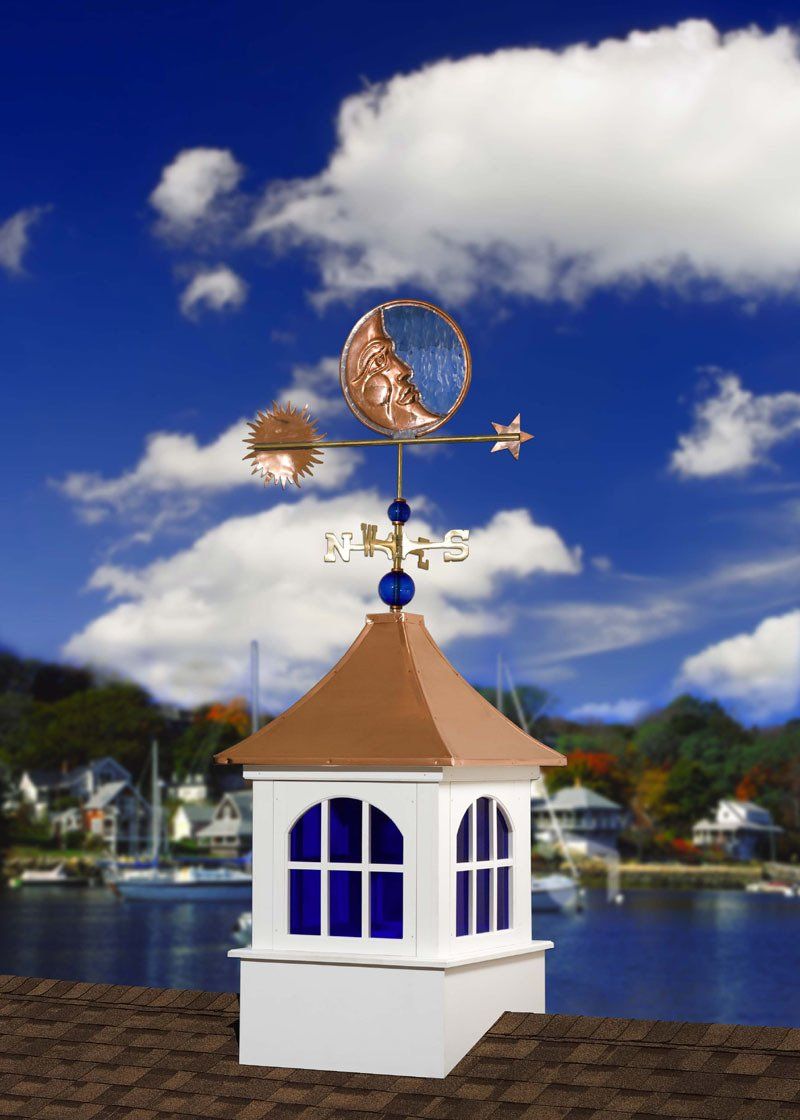 A weather vane on top of a small white building