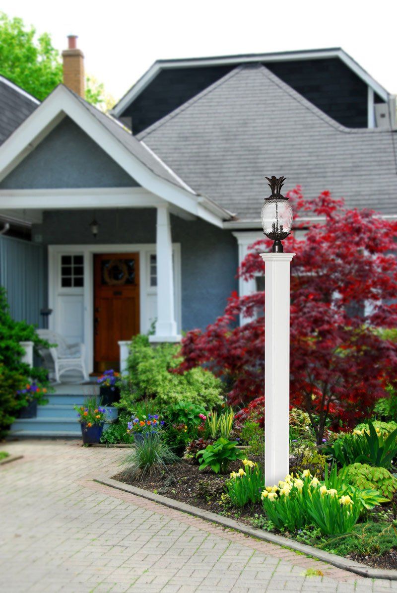 A house with a brick driveway and a lamp post in front of it