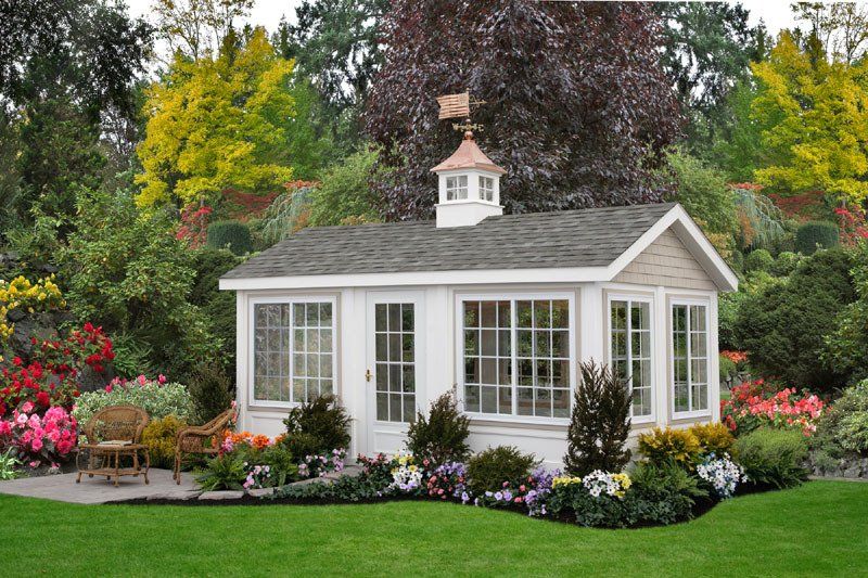 A white house with a weather vane on top of it