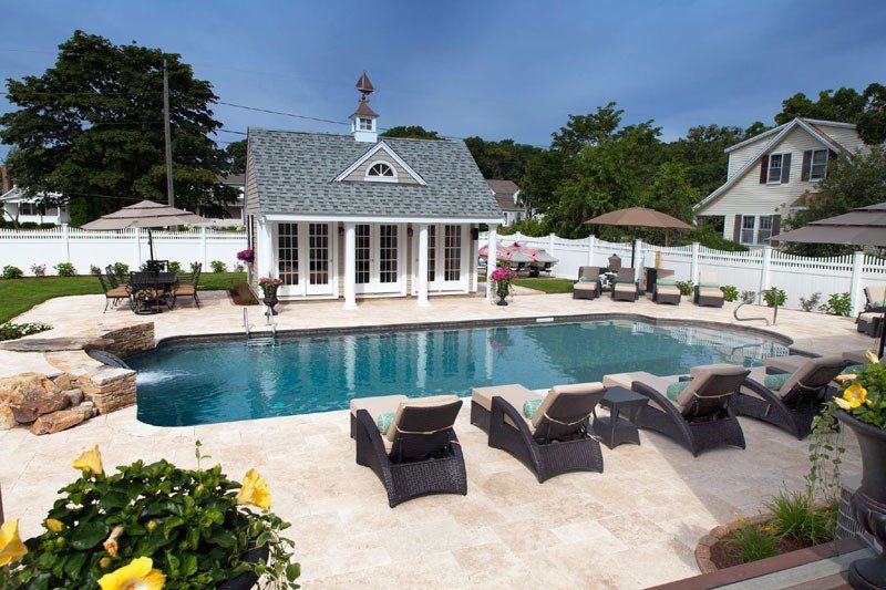A large swimming pool is in the backyard of a house