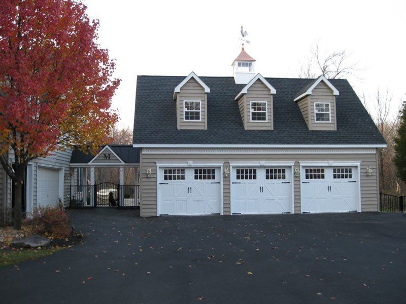 A house with three garage doors and a cupola on top