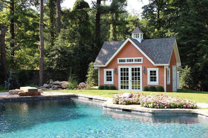A small house with a pool in front of it