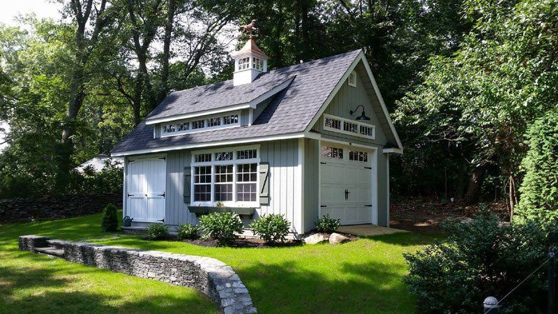 A small house is sitting on top of a lush green hill.