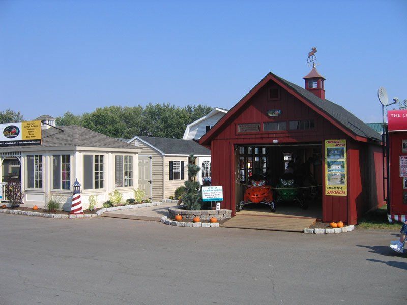 A red shed with a weather vane on top of it