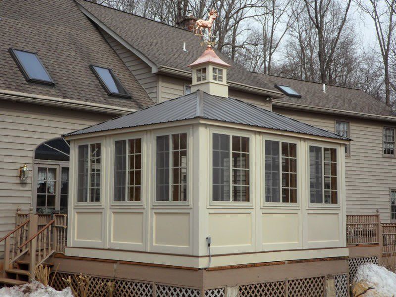 A gazebo with a weather vane on top of it