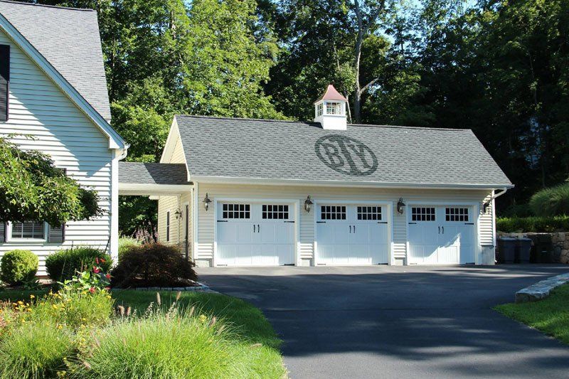 A white garage with the letter g on the roof
