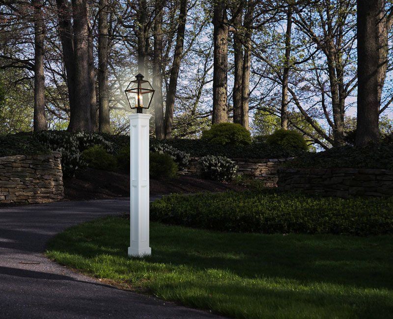 A white pole with a light on top of it