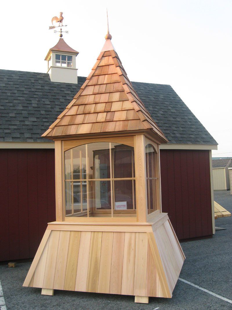 A wooden tower with a weather vane on top of it