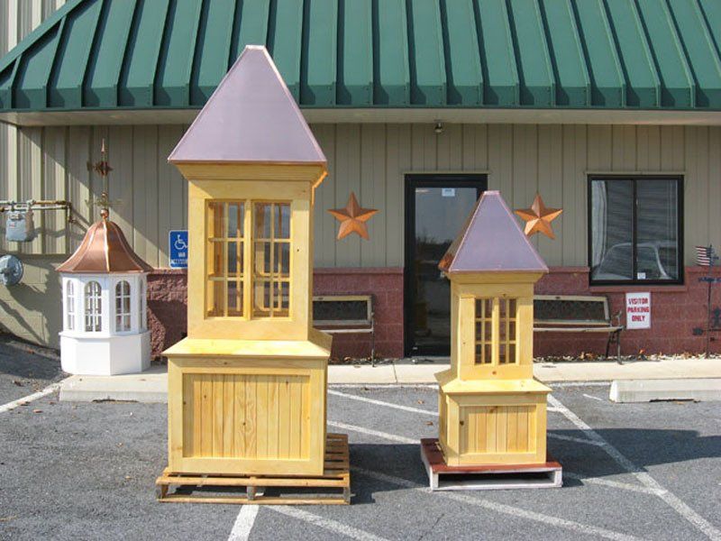 Two small wooden houses are sitting in front of a building