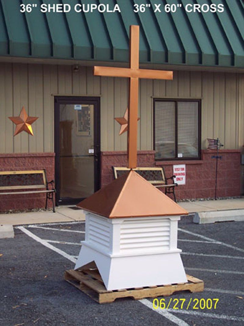 A shed cupola with a cross on top of it