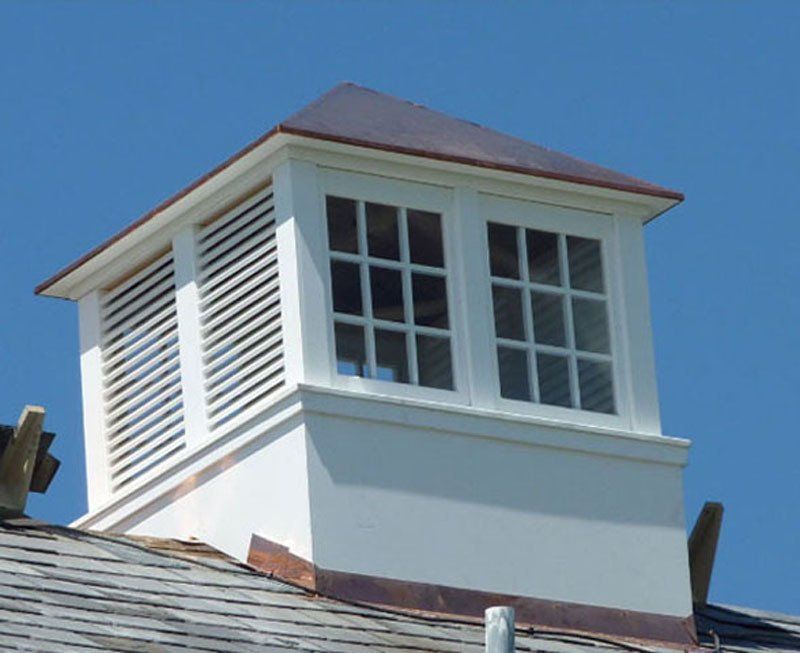 A white building with a cupola on top of it