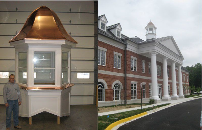A man standing next to a copper roof next to a large brick building