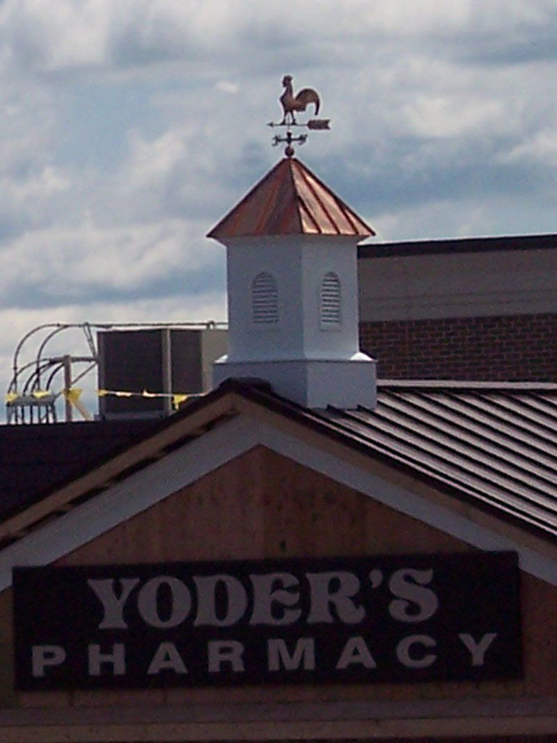 Yoder 's pharmacy has a weather vane on top of it