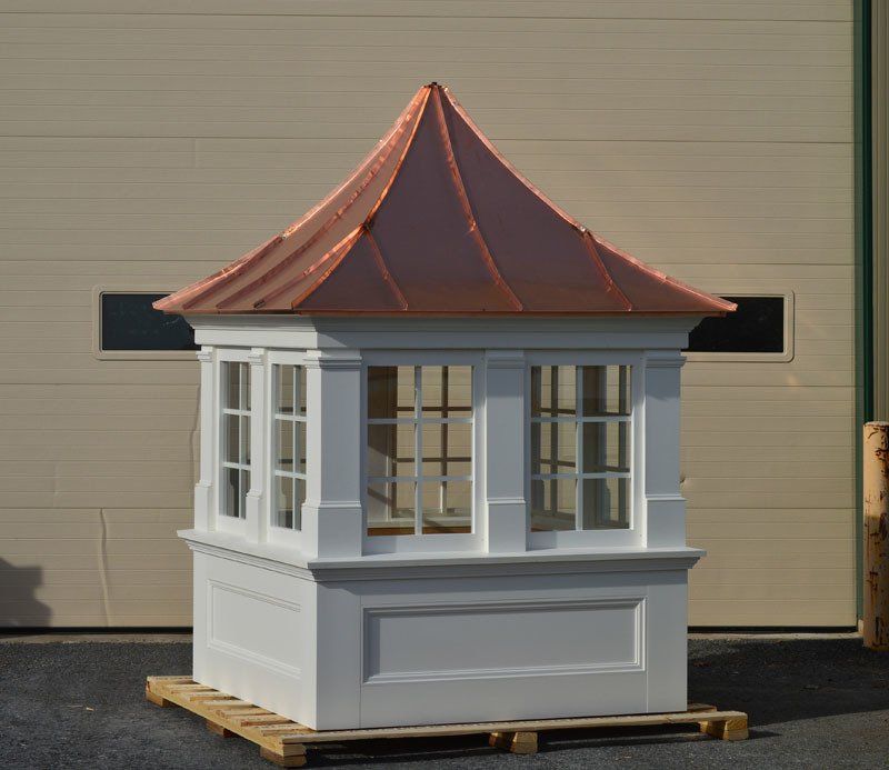 A small white building with a copper roof