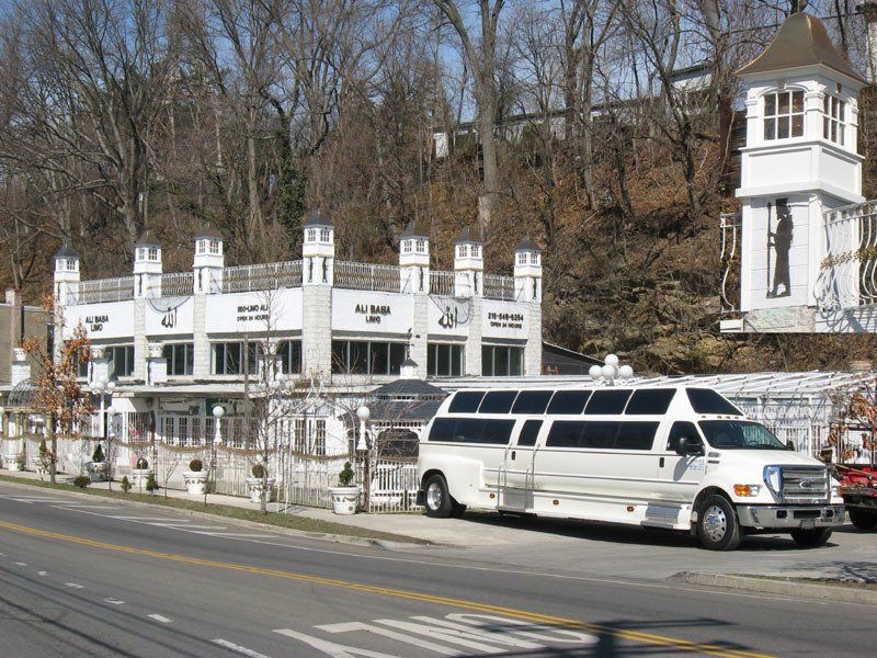 A white van is parked on the side of the road in front of a building