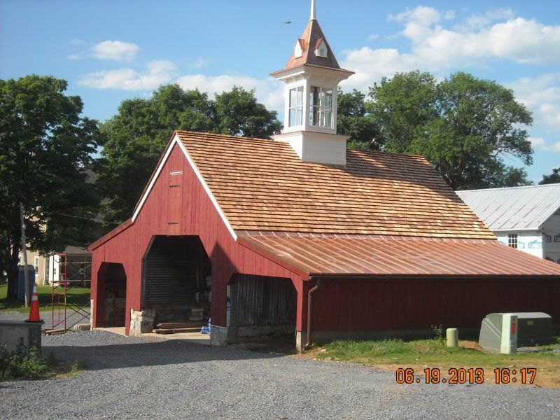 A red barn with a clock tower on top of it