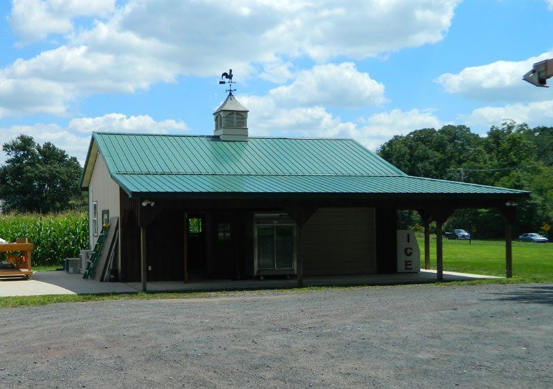 A small house with a green roof and a weather vane on top