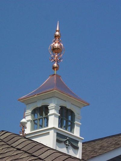a white building with a copper tower on top of it