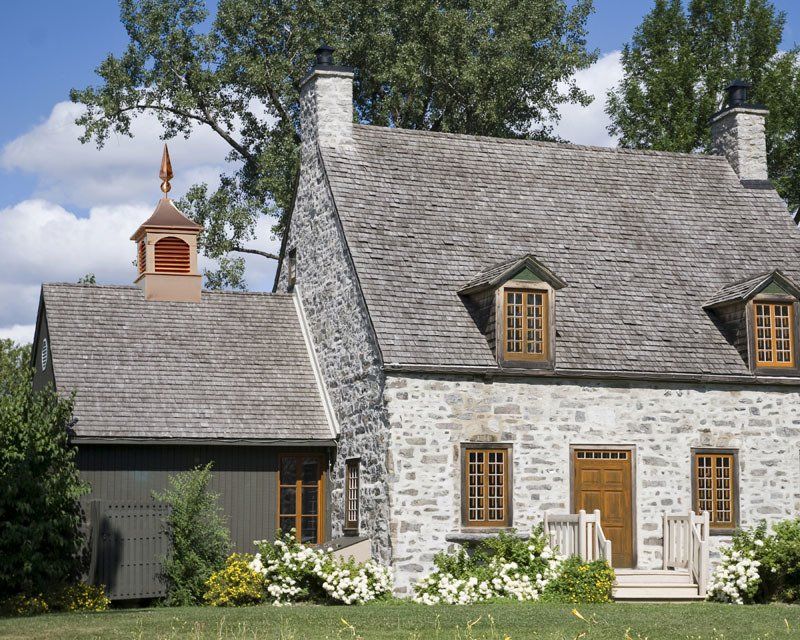 A large stone house with a chimney on top of it