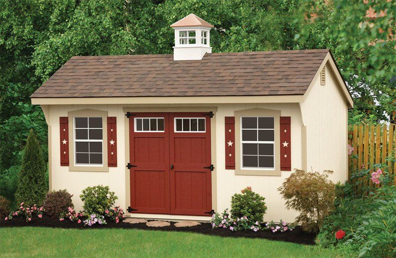 A white shed with red doors and shutters