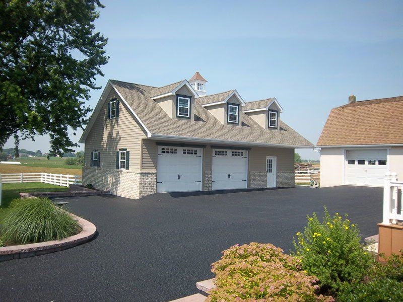 A large house with three garage doors and a driveway