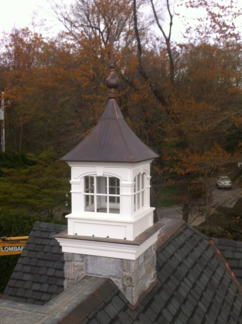 A chimney on top of a roof with trees in the background