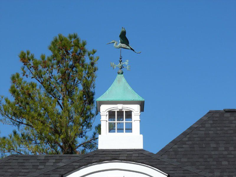 A weather vane with a bird on top of it