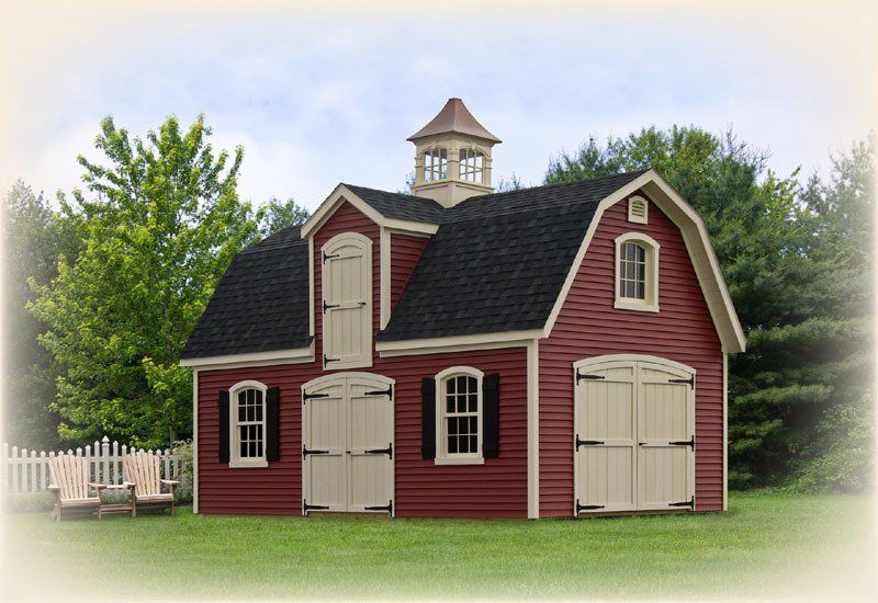 A red barn with a cupola on top of it