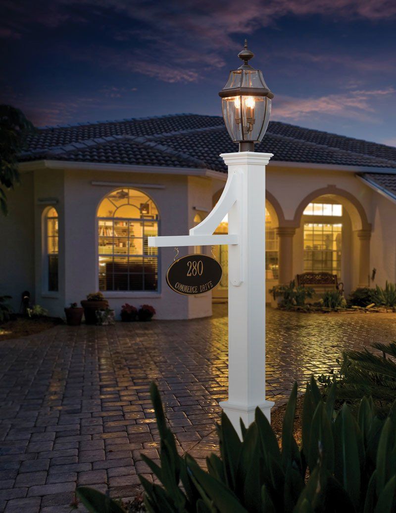 A white mailbox is lit up in front of a house