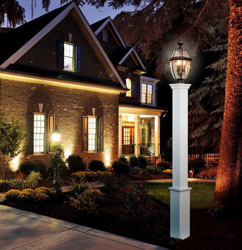 A brick house with a white lamp post in front of it