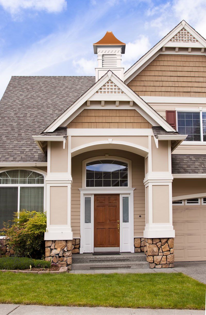 A large house with a large porch and a gray roof.