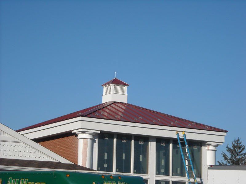 A building with a red roof and a ladder on the side