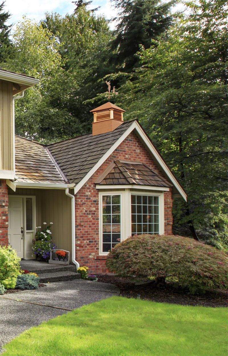 A small brick house with a chimney on the roof