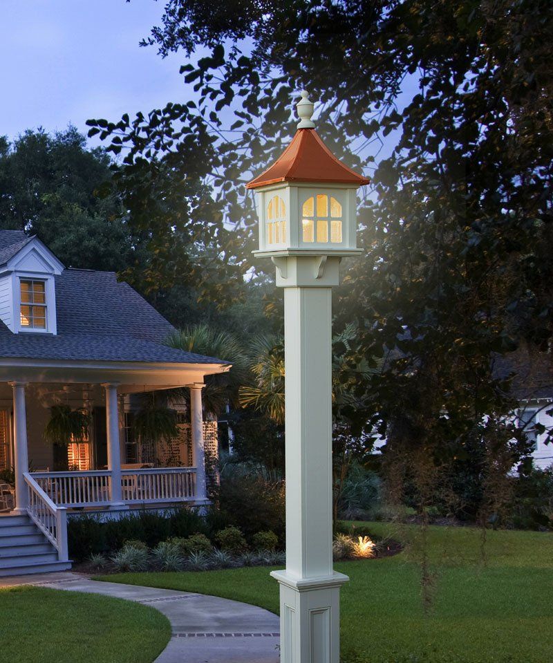 A white pole with a red roof is lit up in front of a house