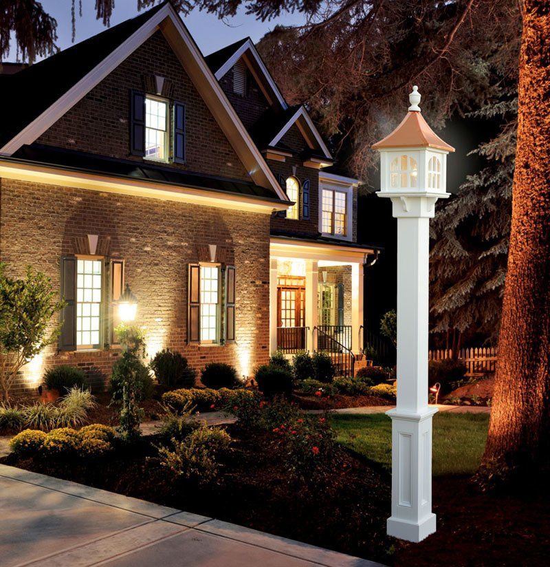 a brick house with a white lamp post in front of it
