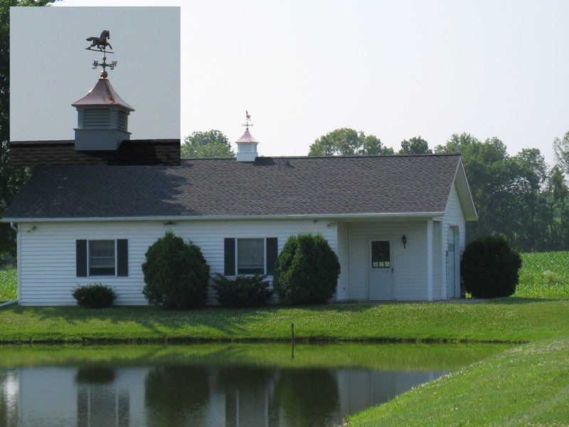 A white house with a weather vane on top of it