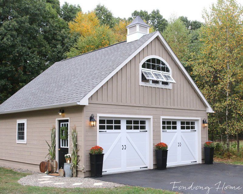 A garage with two white garage doors and a gray roof