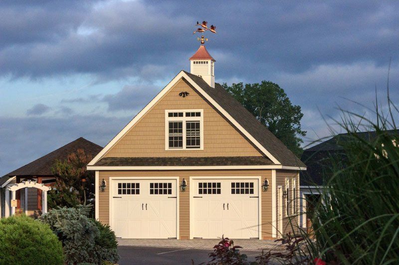 A garage with a weather vane on top of it