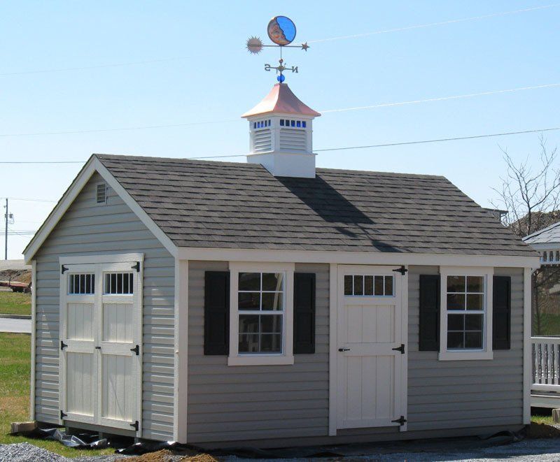 A small house with a weather vane on top of it