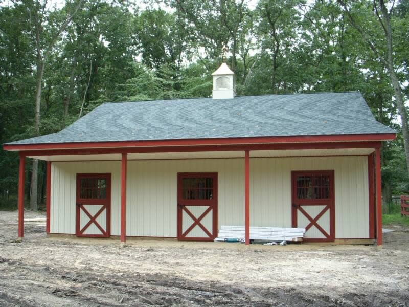 A white building with red doors and a black roof