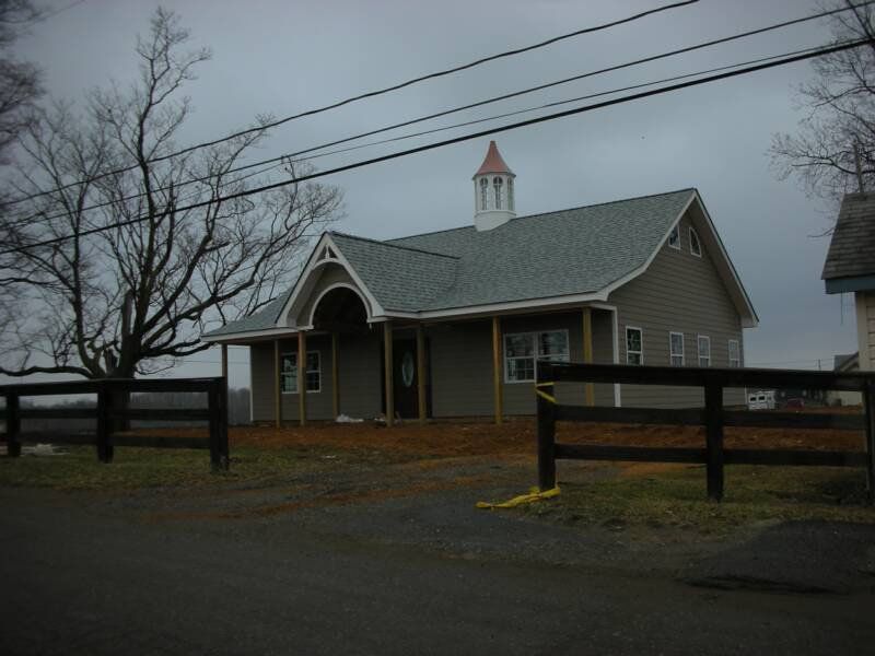 A house with a fence in front of it on a cloudy day