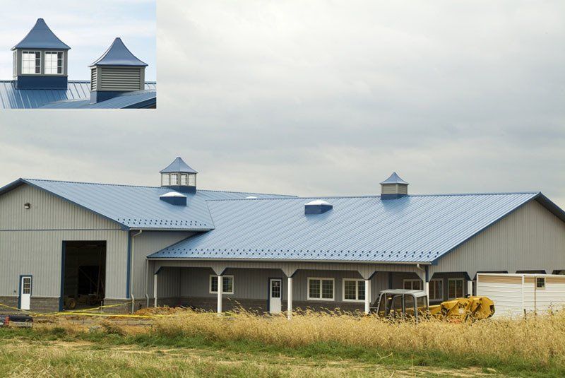 A tractor is parked in front of a building with a blue roof