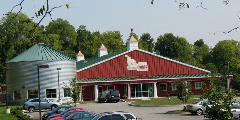 A red barn with a silo in front of it